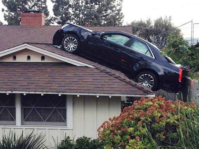  The car "parked" on the roof of the house.